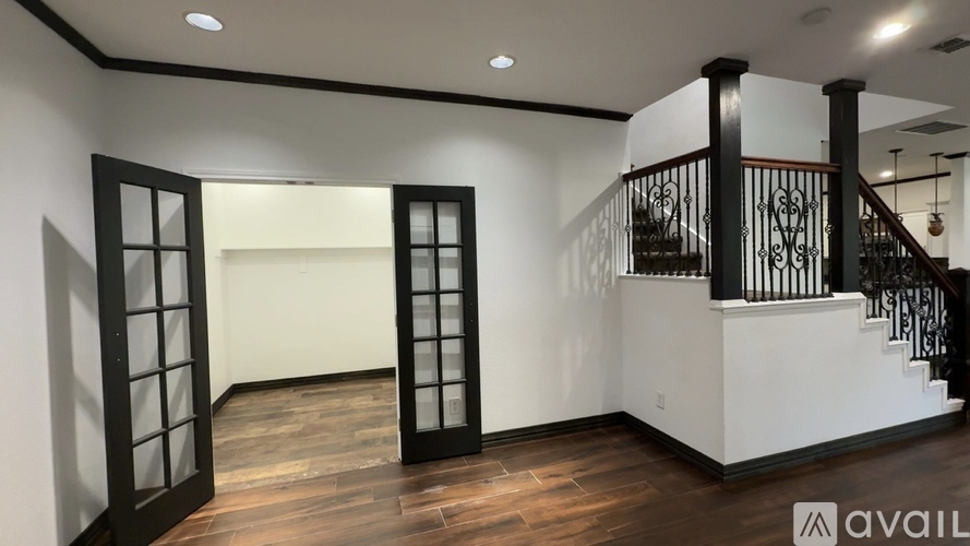 A room with a staircase and a balcony with a railing.