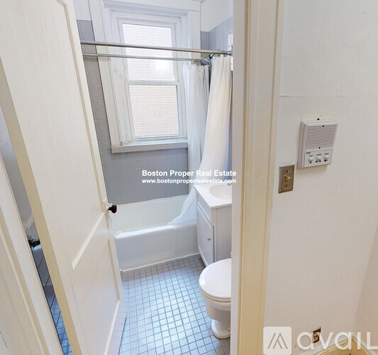 A small bathroom with a toilet, tub, and window.