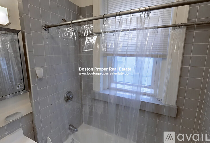 A shower area with a glass door and a window.
