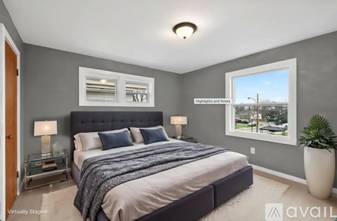 A bedroom with a large bed and a window overlooking a street.