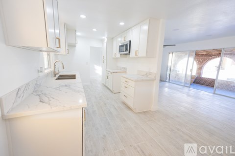 A modern kitchen with white cabinets and a marble countertop.
