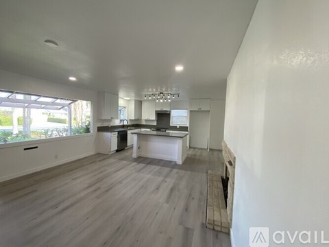 A spacious kitchen with white cabinets and a dining area with a table and chairs.