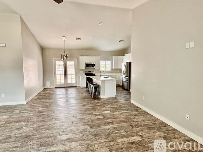A living room with a kitchen in the background.