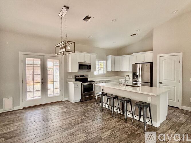 A modern kitchen with white cabinets and a large island.