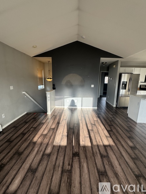 A room with wooden floors and a person standing in the middle.