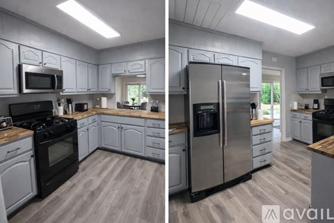 A modern kitchen with stainless steel appliances and wooden floors.