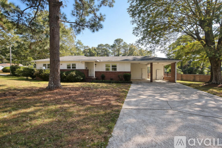 A house with a driveway and trees in front.
