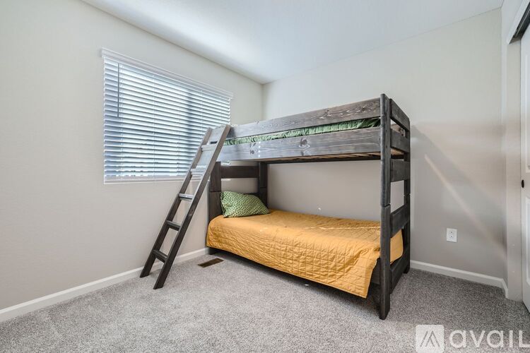 A bedroom with a bunk bed and a ladder.