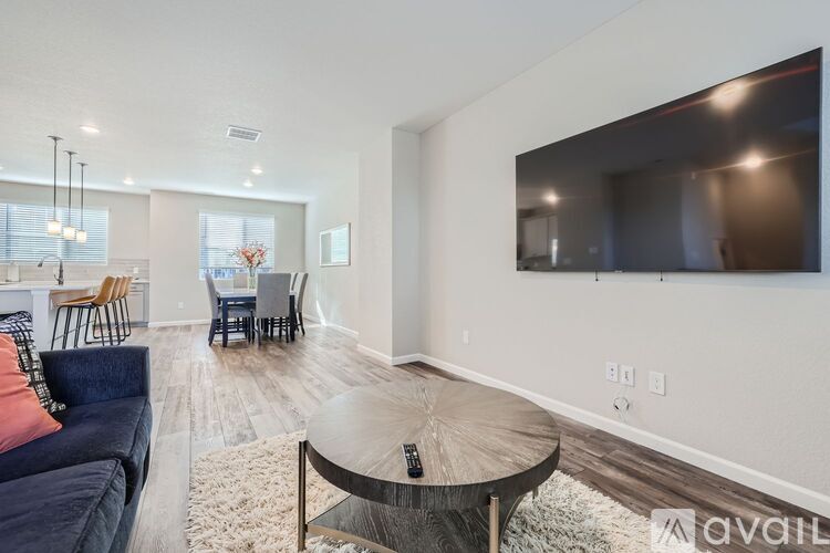 A living room with a couch, chairs, and a television.