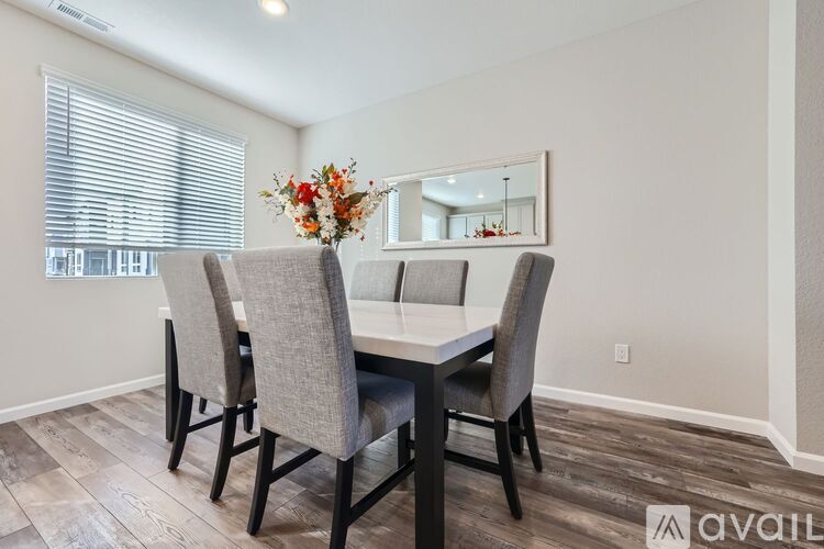 A dining room with a table and chairs.