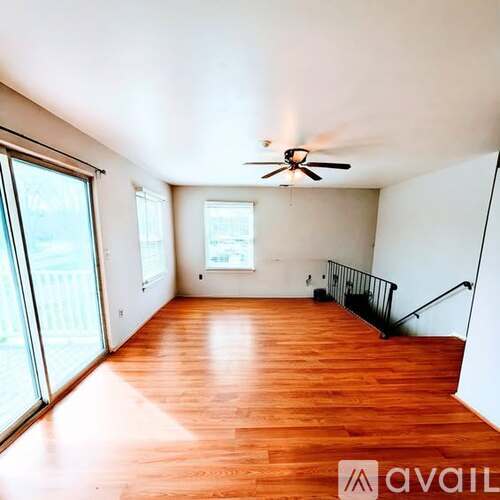 A room with wooden floors and a ceiling fan.