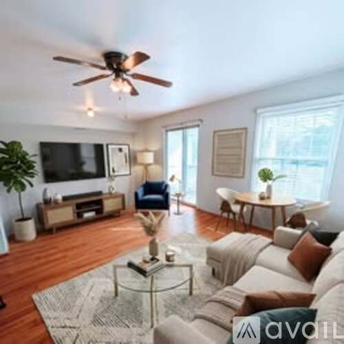 A living room with a white couch and a glass coffee table.