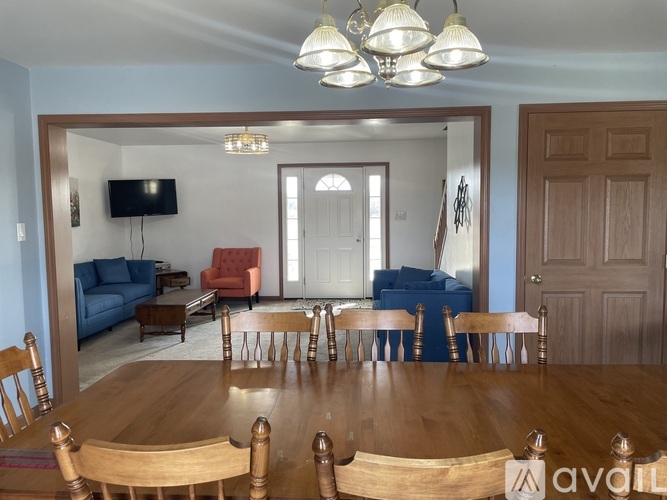 A dining room with a wooden table and chairs.