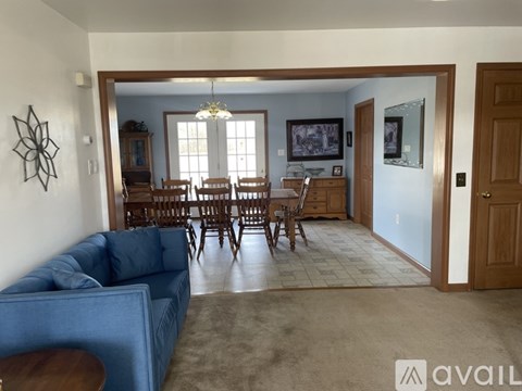 A living room with a blue couch and a wooden table.