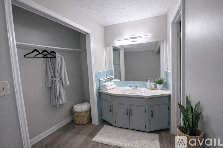 A bathroom with a grey cabinet, a white sink, and a mirror.