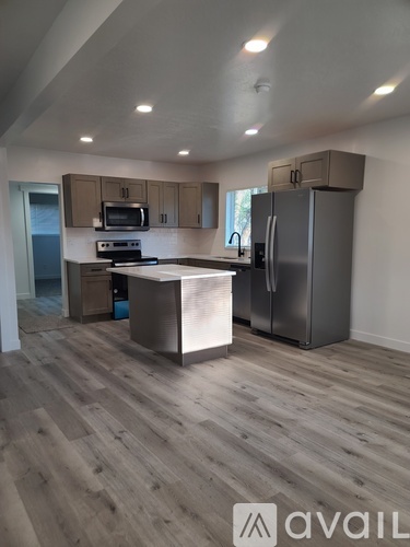 A kitchen with wooden floors and a refrigerator.
