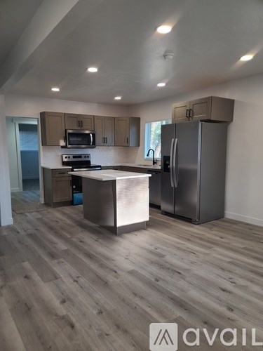 A kitchen with wooden floors and a refrigerator.