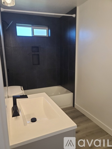 A bathroom with a white sink and a black shower.