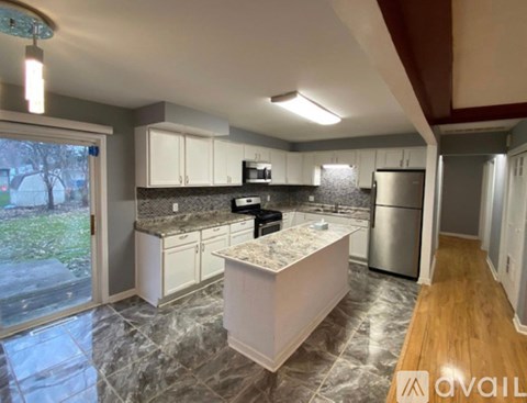 A kitchen with a marble countertop and white cabinets.