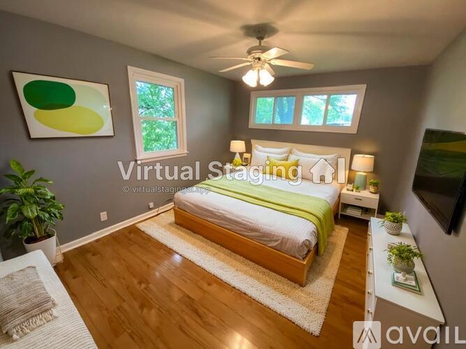 A bedroom with a bed, a ceiling fan, and a window.
