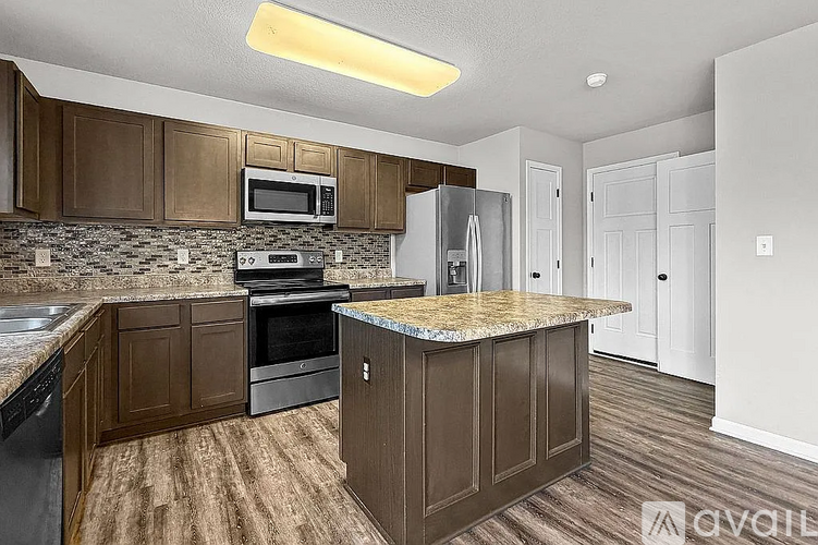 A kitchen with brown cabinets and a granite countertop.