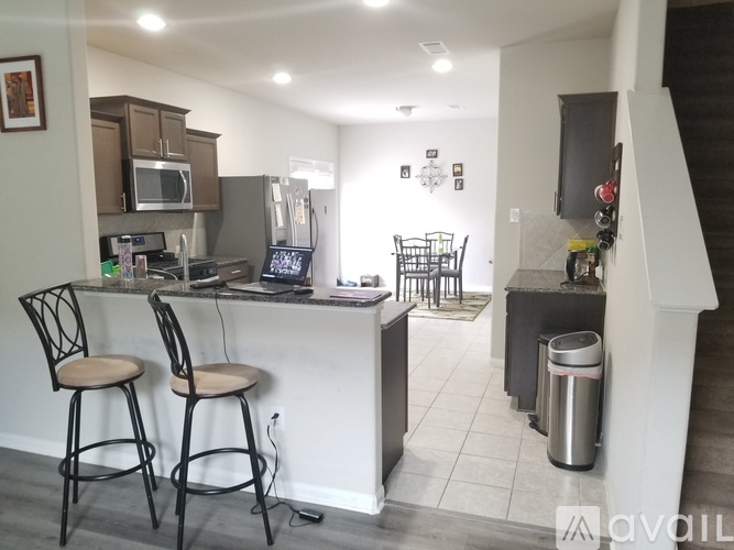 A kitchen with a bar area and two chairs.