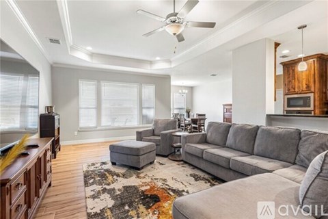 A living room with a grey sofa, a wooden cabinet, and a rug on the floor.