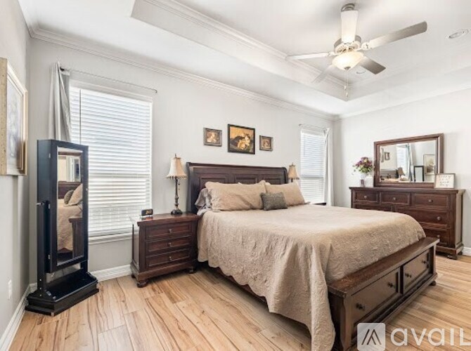 A bedroom with a large bed, a dresser, and a mirror.