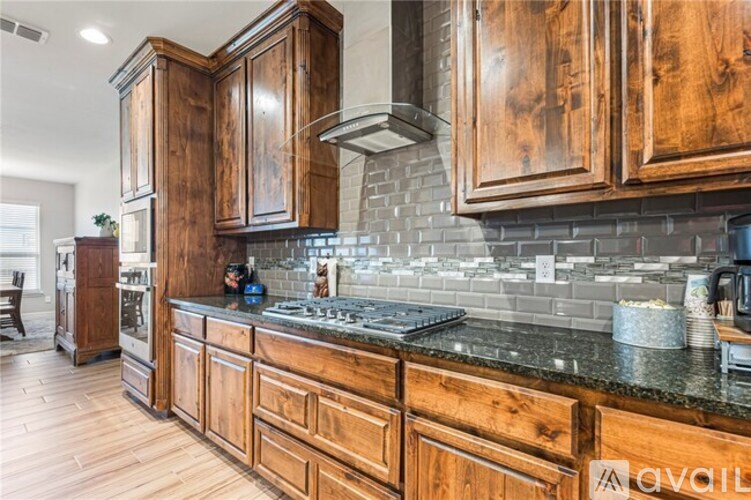 A kitchen with wooden cabinets and a black countertop.