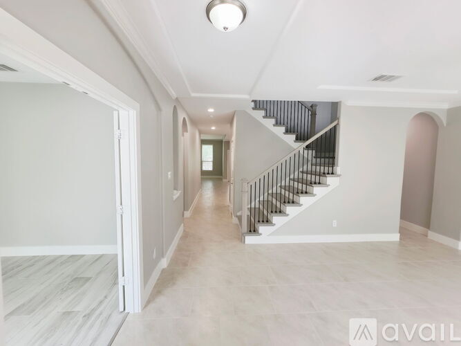A spacious hallway with a staircase leading to the second floor.