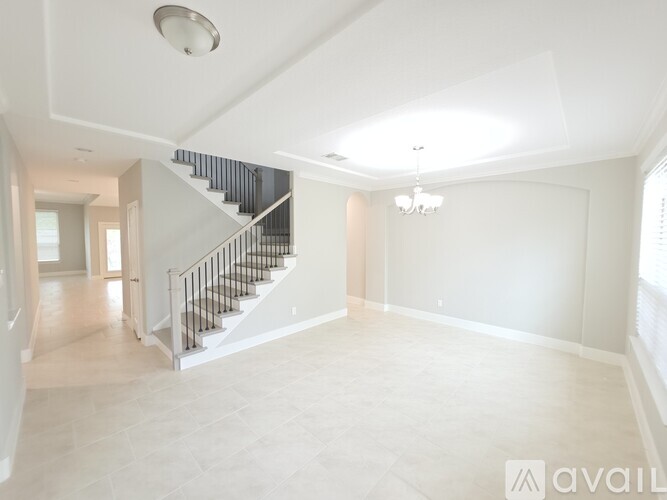 A room with a ceiling fan and wooden flooring.