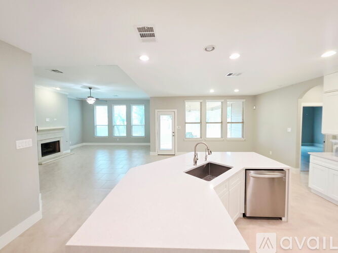 A spacious kitchen with a white countertop and stainless steel appliances.