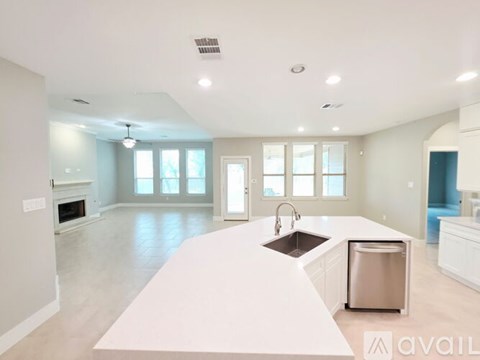 A spacious kitchen with a white countertop and stainless steel appliances.