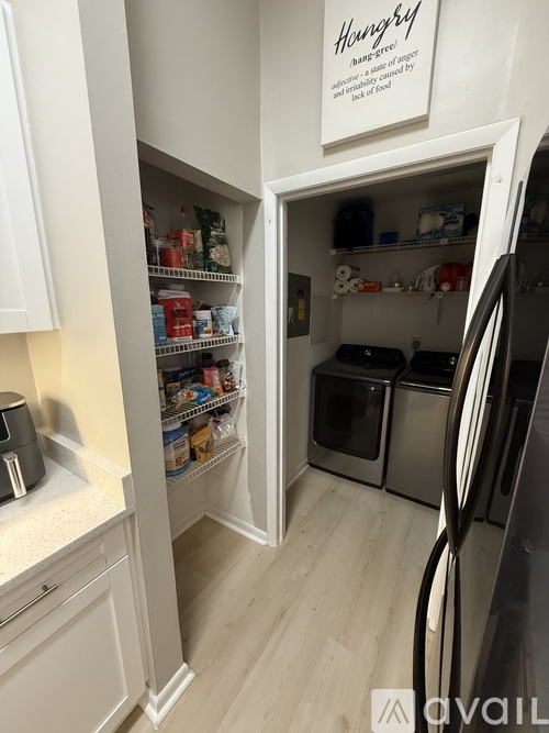 A kitchen with a refrigerator, oven, and cabinets.