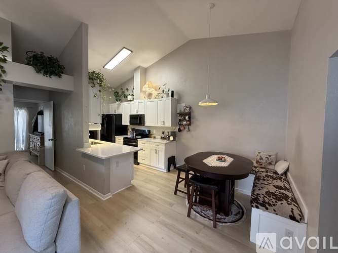 A modern kitchen with a dining table and a couch.