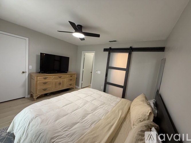 A bedroom with a large bed and a flat screen TV.