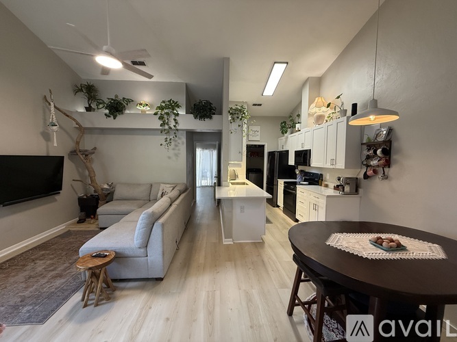 A living room with a couch, a television, and a dining table.