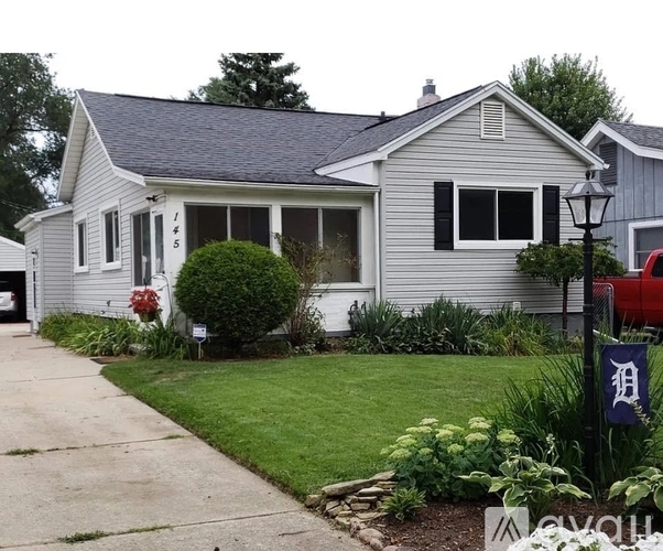 A house with a Detroit Tigers flag on a lamp post.