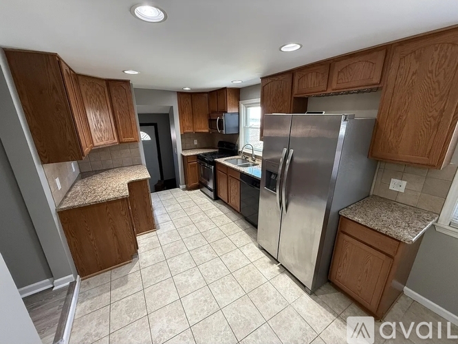 A kitchen with wooden cabinets and a refrigerator.