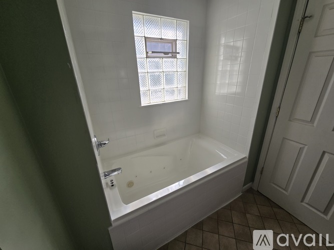 A bathroom with a tub and a window.