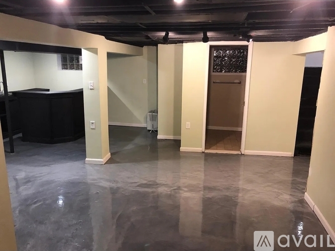 A spacious room with a black cabinet and a glass door.