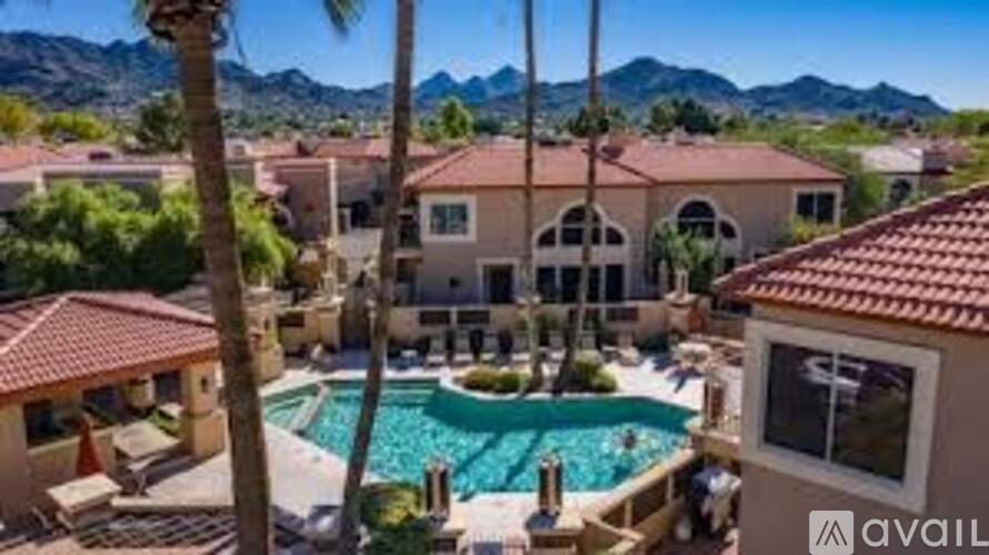 A house with a pool and palm trees in front.