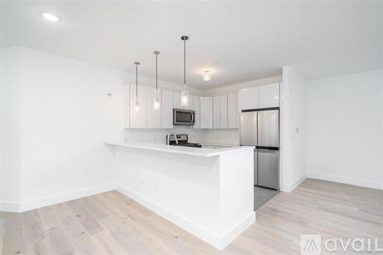 A kitchen with a white counter and wooden floors.
