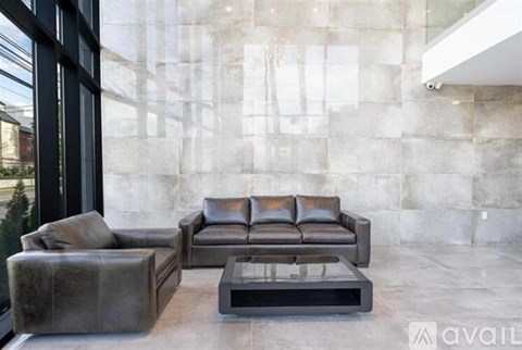 A modern living room with a grey sofa and a glass table.