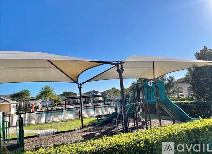 A playground with a green slide and a white canopy.