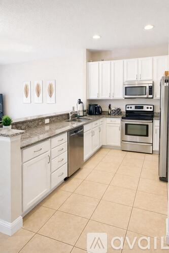 A kitchen with white cabinets and a granite countertop.