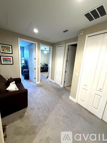 A living room with a couch and a wall with pictures.