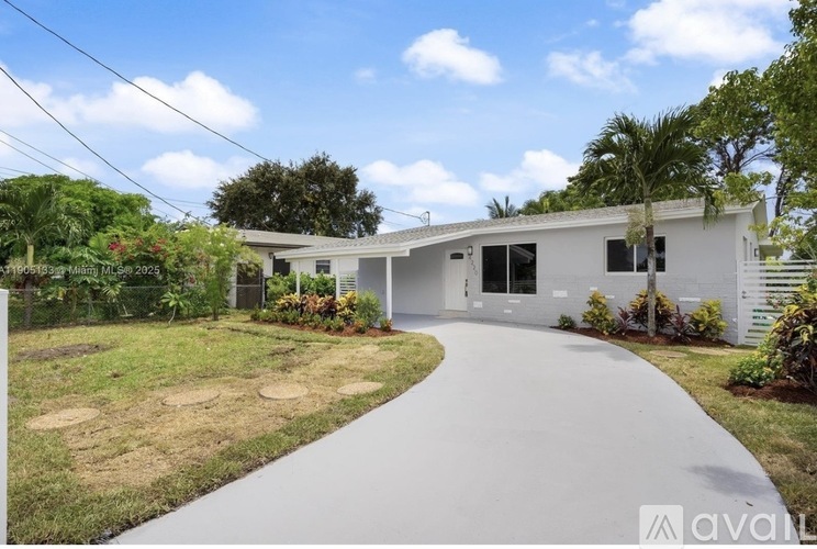 A modern house with a white exterior and a long driveway leading to the front door.