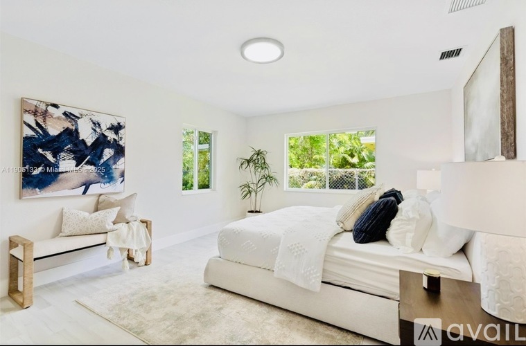 A bedroom with a large bed and a painting on the wall.