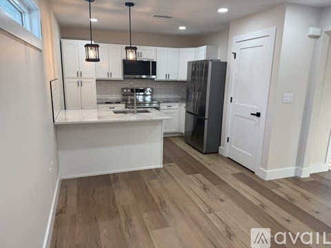 A kitchen with a refrigerator, sink, and cabinets.